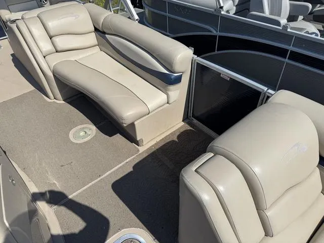 Slide: The Image of 2012 Bennington 2575 RCW boat interior with beige leather seating and carpeted flooring. - 15