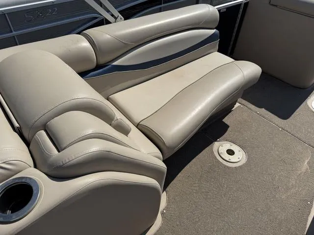 Slide: The Image of 2012 Bennington 2575 RCW boat interior with beige seating and cup holder. - 16