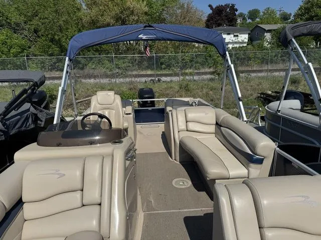 Slide: The Image of 2012 Bennington 2575 RCW pontoon boat with beige seating and blue canopy. - 9