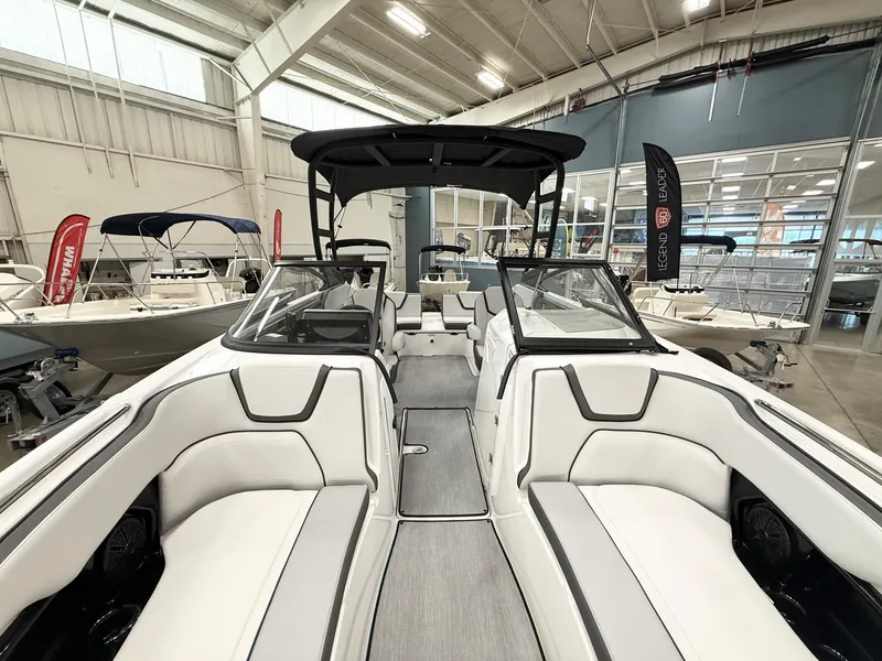 Slide: The Image of 2025 Yamaha Boats AR250 interior with sleek white seating in a showroom. - 11