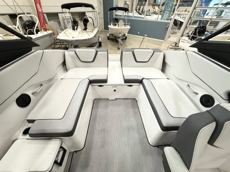 Slide: The Image of 2025 Yamaha Boats AR250 interior with sleek seating and modern design in a showroom. - 7