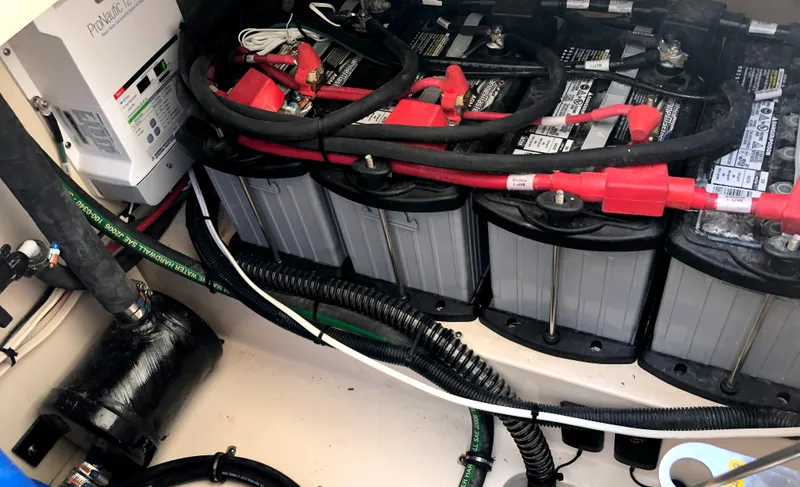 Slide: The Image of 2023 Grady-White Freedom 375 boat battery compartment with multiple batteries and wiring. - 11