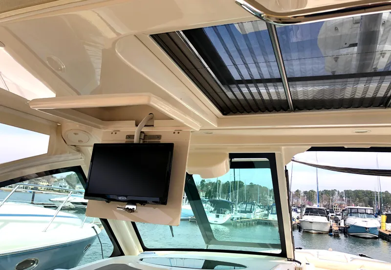 Slide: The Image of 2023 Grady-White Freedom 375 boat interior with TV and marina view. - 24