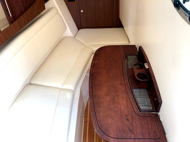 Slide: The Image of Interior of 2023 Grady-White Freedom 375 boat with white seating and wooden table. - 26