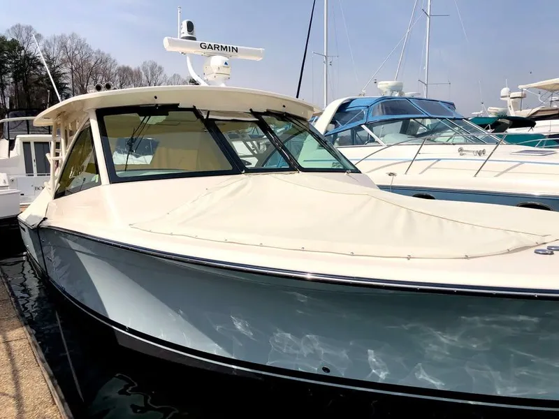 Slide: The Image of 2023 Grady-White Freedom 375 boat docked, featuring sleek design and Garmin equipment. - 37