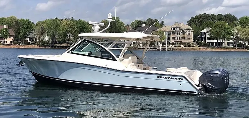 Slide: The Image of 2023 Grady-White Freedom 375 boat on a lake with waterfront homes in the background. - 39
