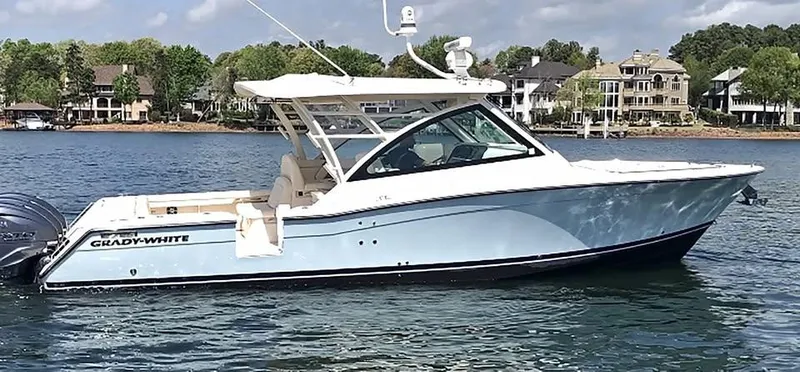 Slide: The Image of 2023 Grady-White Freedom 375 boat on a serene lake with luxury homes in the background. - 40