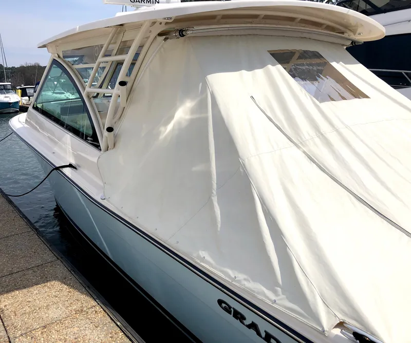 Slide: The Image of 2023 Grady-White Freedom 375 boat docked, featuring a sleek design and covered cabin. - 5