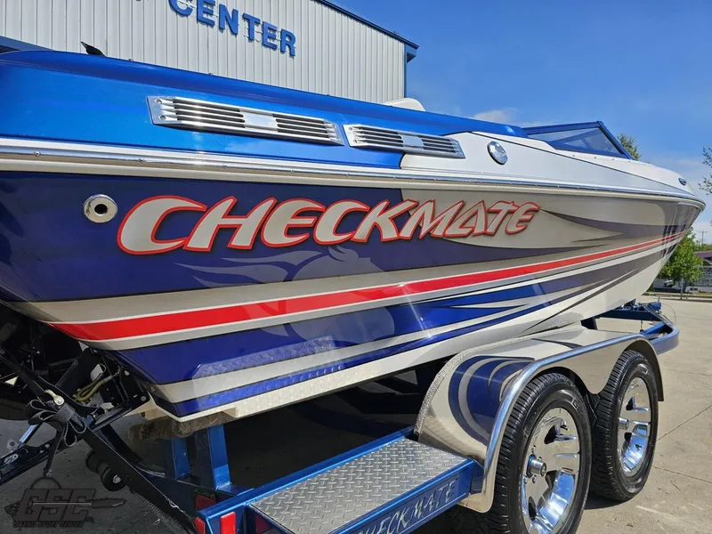 Slide: The Image of 2012 Checkmate ZT 230 BR boat with vibrant blue and red design on a trailer. - 11