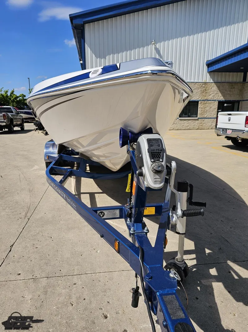 Slide: The Image of 2012 Checkmate ZT 230 BR boat on trailer, parked outside industrial building. - 14