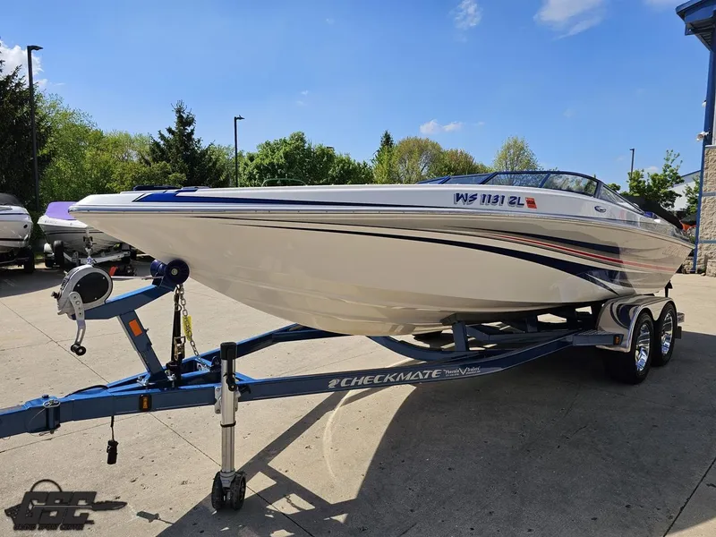 Slide: The Image of 2012 Checkmate ZT 230 BR boat on trailer, parked outdoors under clear sky. - 17