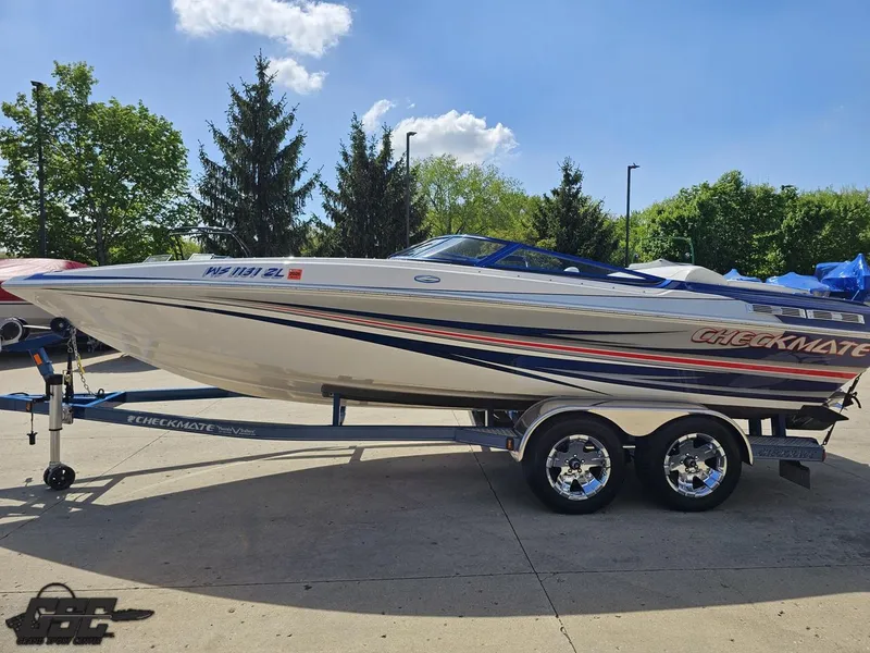 Slide: The Image of 2012 Checkmate ZT 230 BR boat on trailer, parked outdoors under clear sky. - 19