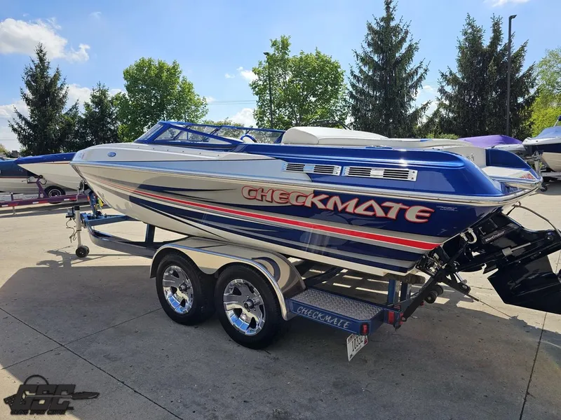 Slide: The Image of 2012 Checkmate ZT 230 BR speedboat on trailer, blue and white design, parked outdoors. - 25