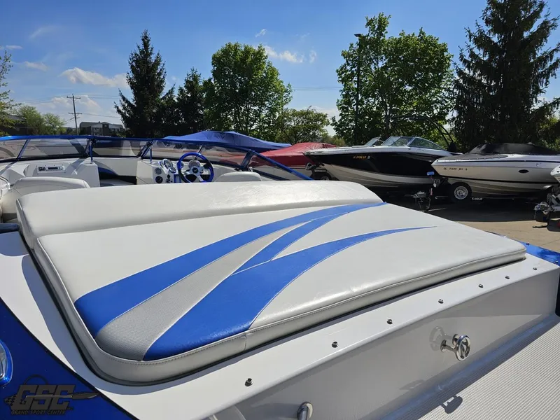 Slide: The Image of 2012 Checkmate ZT 230 BR boat with blue and white seating, parked outdoors. - 36