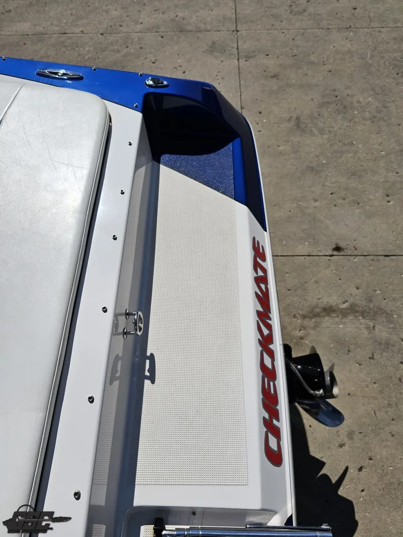 Slide: The Image of 2012 Checkmate ZT 230 BR boat stern with logo, docked on concrete surface. - 37