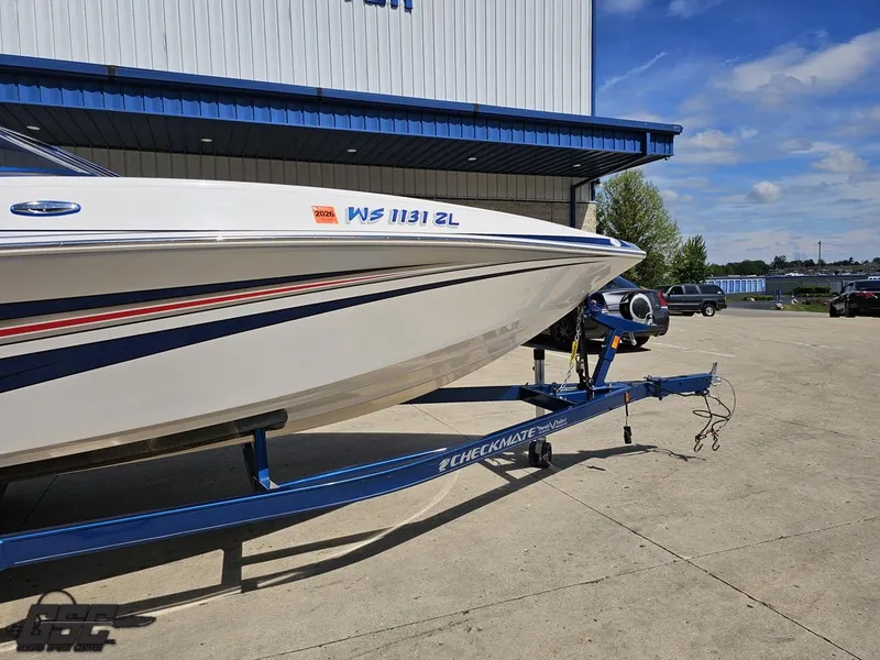 Slide: The Image of 2012 Checkmate ZT 230 BR boat on trailer, parked outside a building under a clear sky. - 6