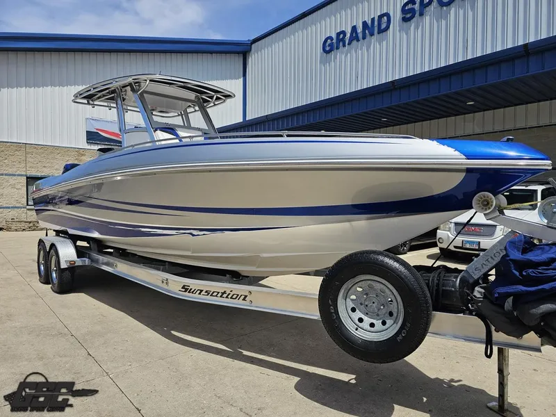 Slide: The Image of 2017 Sunsation 29 CCX boat on trailer, parked outside dealership under blue sky. - 13