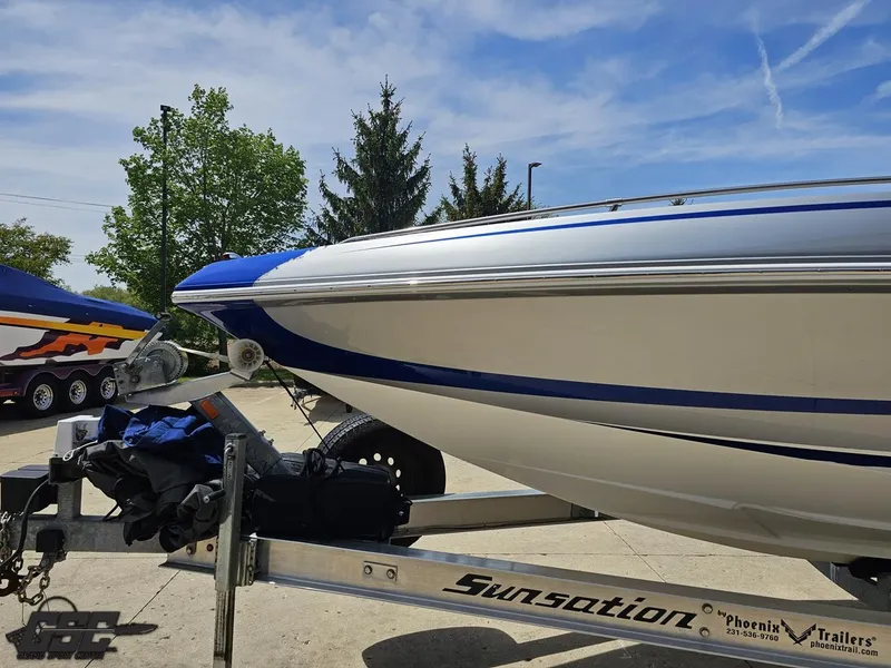 Slide: The Image of 2017 Sunsation 29 CCX boat on trailer, blue and white design, parked outdoors. - 14