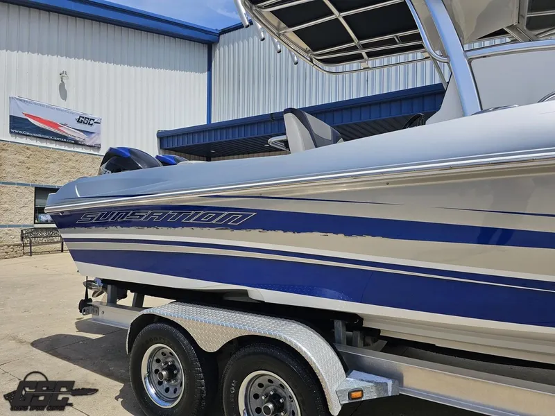 Slide: The Image of 2017 Sunsation 29 CCX boat on trailer, blue and silver design, parked outside a building. - 5