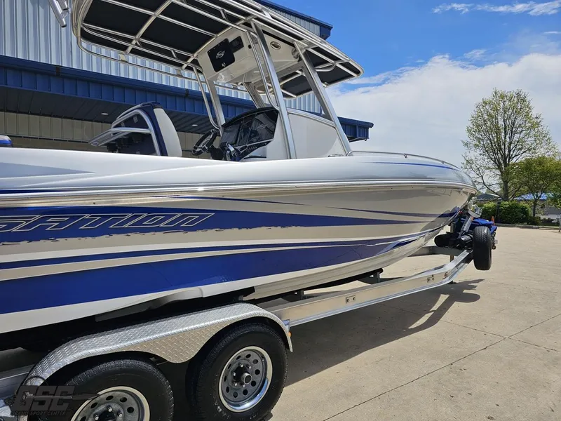 Slide: The Image of 2017 Sunsation 29 CCX boat on trailer, blue and white design, parked outdoors. - 8