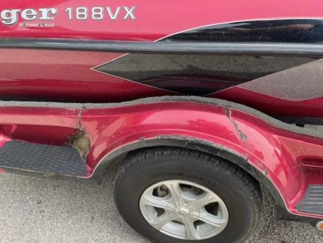 Slide: The Image of Red 2011 Ranger 188 VX boat trailer with visible wear and damage. - 14
