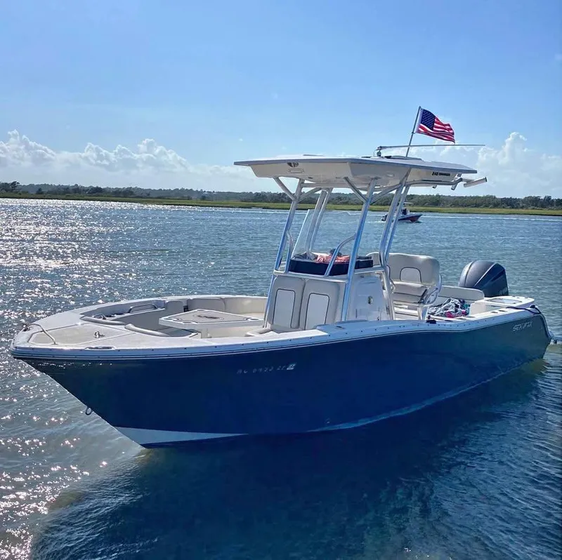 Slide: The Image of 2021 Sea Fox 248 Commander boat on water, sunny day, American flag flying. - 12