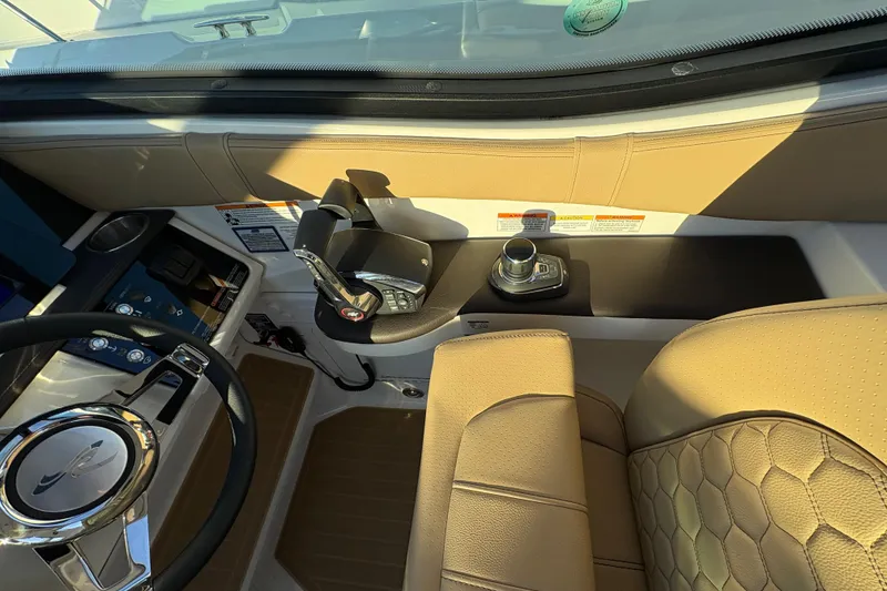 Slide: The Image of 2026 Sea Ray Sundancer 320 Outboard helm with modern controls and beige seating. - 11