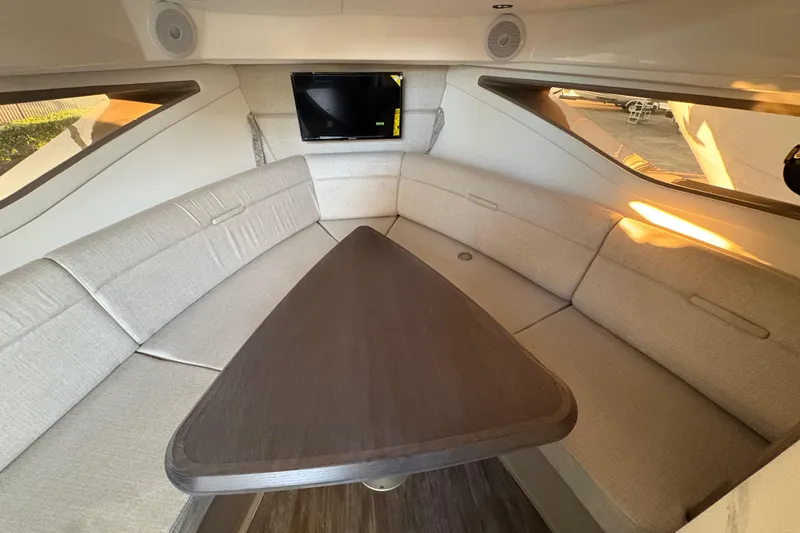 Slide: The Image of Interior of 2026 Sea Ray Sundancer 320 Outboard with cozy seating and a mounted TV. - 18
