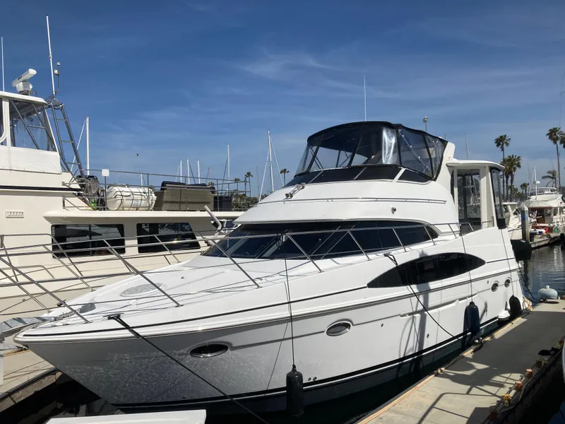 The Image of 2001 Carver 396 Aft Cabin yacht docked at marina under clear blue sky. - 0