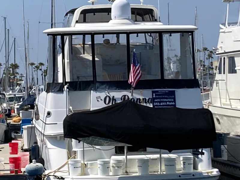 Slide: The Image of 2001 Carver 396 Aft Cabin yacht docked at marina with American flag. - 12
