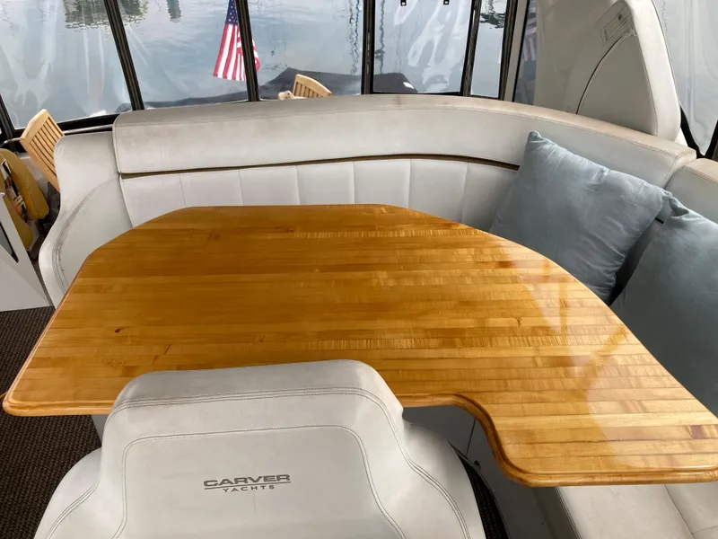 Slide: The Image of Interior of 2001 Carver 396 Aft Cabin yacht with wooden table and cushioned seating. - 17