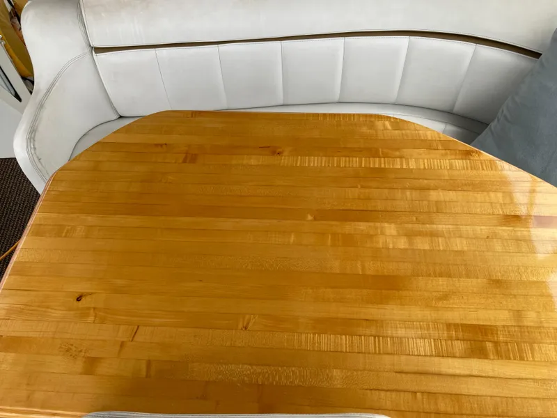Slide: The Image of Wooden table and cushioned seating in a 2001 Carver 396 Aft Cabin yacht interior. - 18