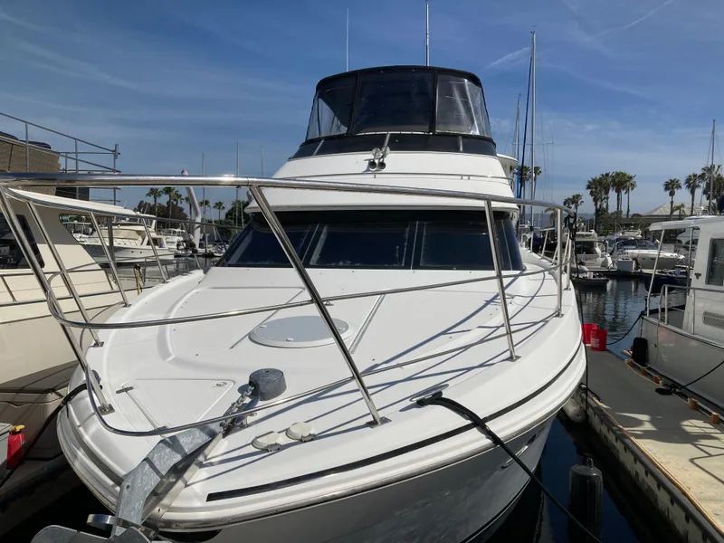 Slide: The Image of 2001 Carver 396 Aft Cabin yacht docked in marina, sunny day, palm trees in background. - 3