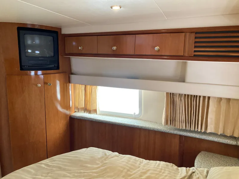 Slide: The Image of Interior of 2001 Carver 396 Aft Cabin with wood cabinetry and TV. - 34