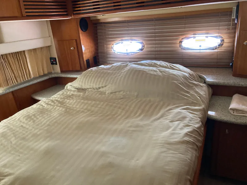 Slide: The Image of 2001 Carver 396 Aft Cabin bedroom with cozy bed and porthole windows. - 37