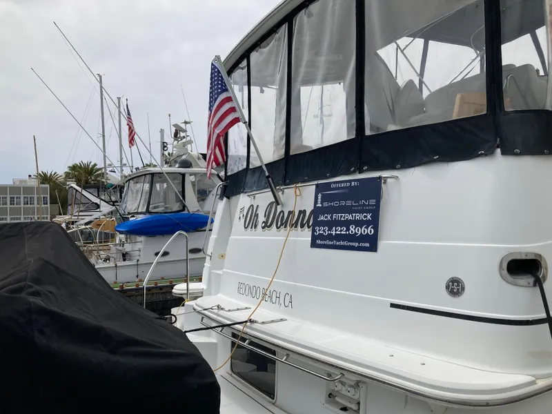 Slide: The Image of 2001 Carver 396 Aft Cabin yacht docked with American flag and contact sign. - 10