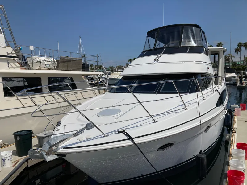 Slide: The Image of 2001 Carver 396 Aft Cabin yacht docked at marina under clear blue sky. - 2