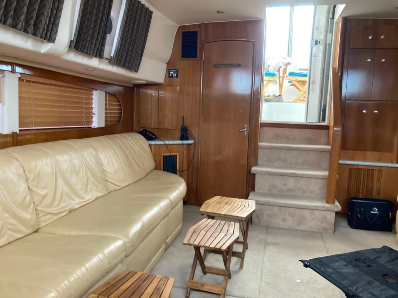 Slide: The Image of Interior of 2001 Carver 396 Aft Cabin yacht with beige sofa and wooden accents. - 24