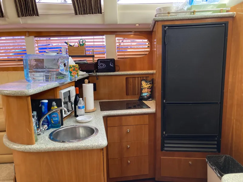 Slide: The Image of 2001 Carver 396 Aft Cabin kitchen with sink, stove, and refrigerator. - 29