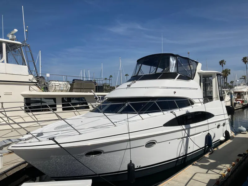 Slide: The Image of 2001 Carver 396 Aft Cabin yacht docked at marina under clear blue sky. - 5