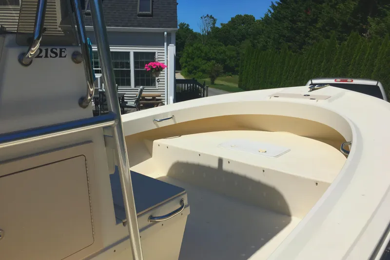 Slide: The Image of 2007 Parker 21 SE CC boat with spacious deck, parked near a house. - 2