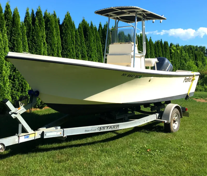 Slide: The Image of 2007 Parker 21 SE CC boat on trailer, parked on grass with trees in background. - 3