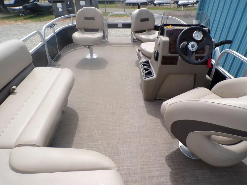 Slide: The Image of 2021 Sun Tracker BASS BUGGY® 16 DLX pontoon boat interior with beige seating and steering console. - 12