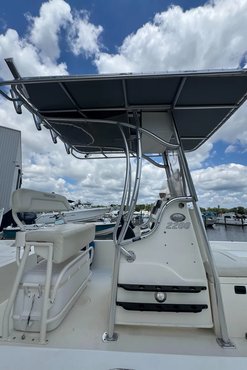 Slide: The Image of 2014 Pathfinder 2200 TRS boat with T-top, docked under a cloudy sky. - 11