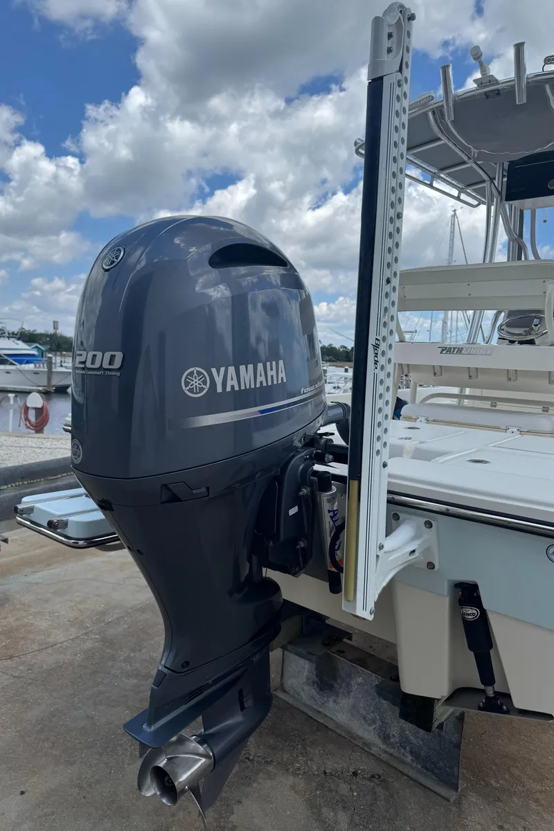 Slide: The Image of 2014 Pathfinder 2200 TRS boat with Yamaha 200 outboard motor, docked under a cloudy sky. - 18