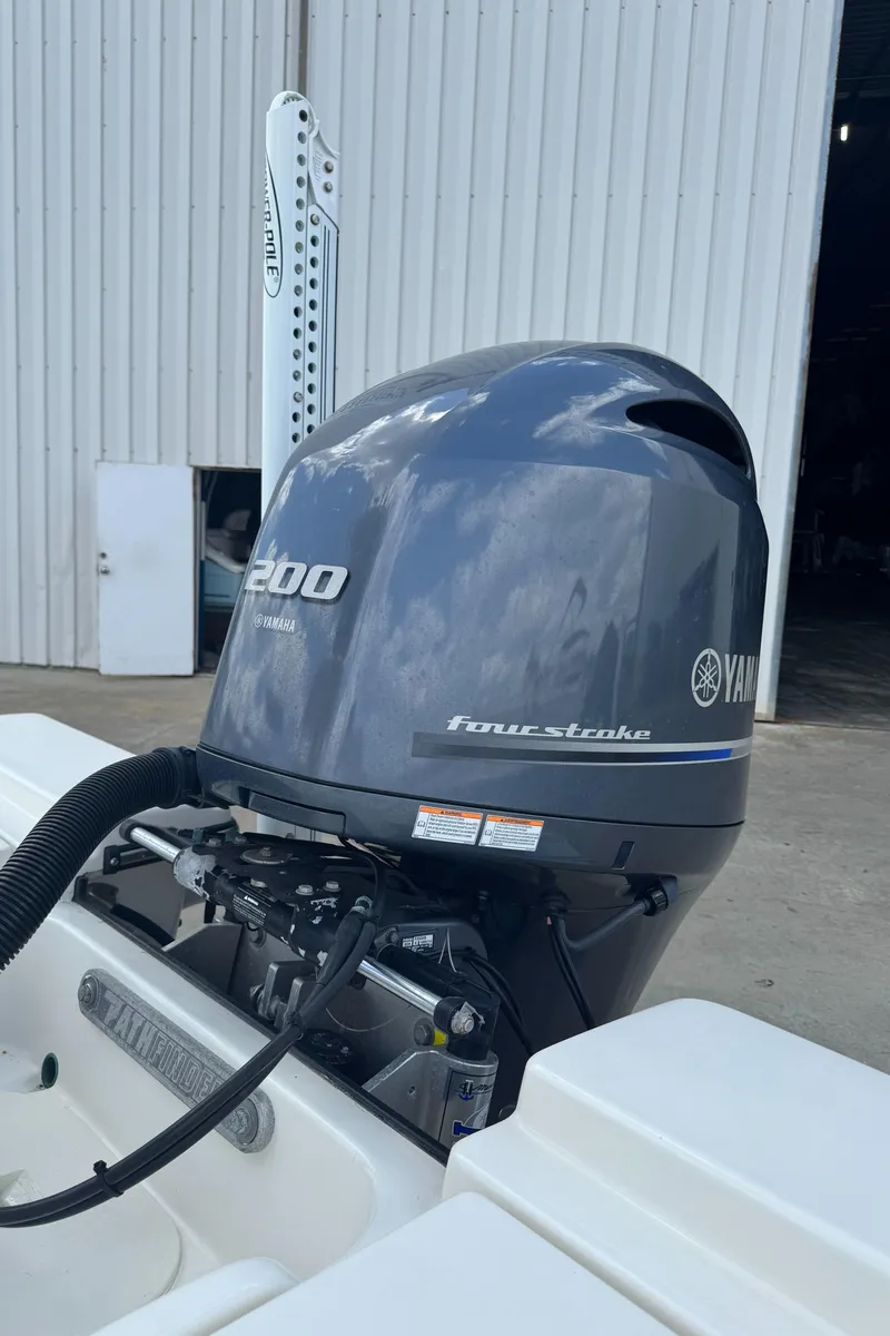 Slide: The Image of 2014 Pathfinder 2200 TRS with Yamaha 200 four-stroke outboard motor, docked near a warehouse. - 20