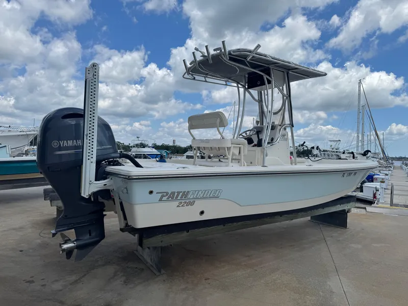 Slide: The Image of 2014 Pathfinder 2200 TRS boat with Yamaha engine, docked under a cloudy sky. - 3