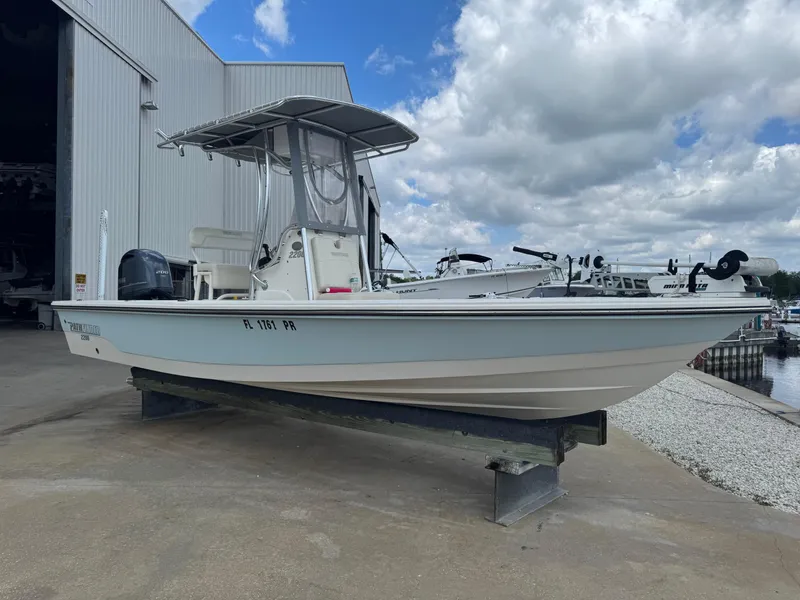 Slide: The Image of 2014 Pathfinder 2200 TRS boat on a stand, near a marina under cloudy skies. - 4