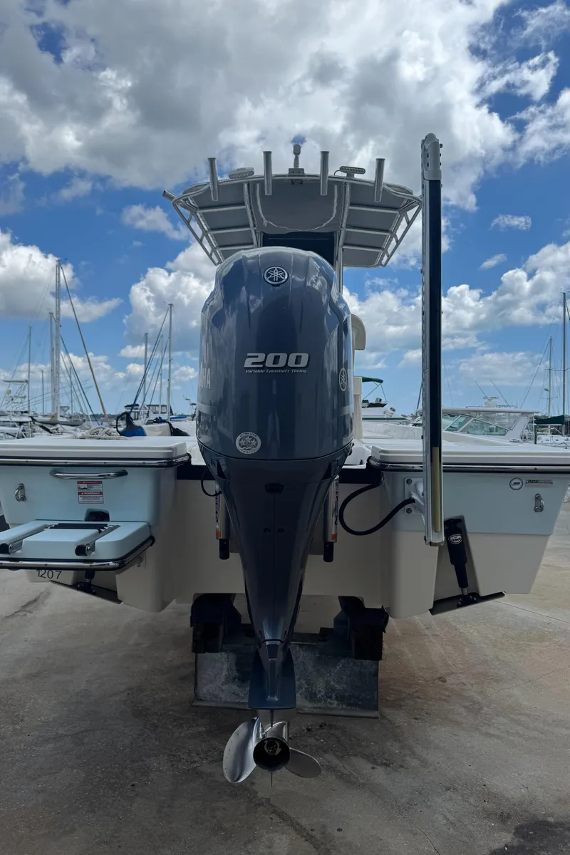 Slide: The Image of 2014 Pathfinder 2200 TRS boat with 200 horsepower engine, docked under a cloudy sky. - 5