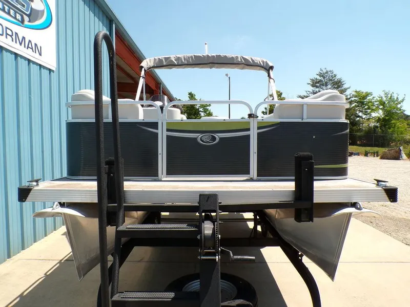 Slide: The Image of 2020 Qwest Edge 816 Cruise pontoon boat on trailer, parked near blue building. - 3